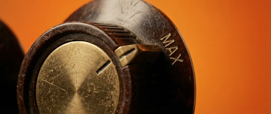 Металева ручка налаштування ISO на камері з позначкою MAX на теплому помаранчевому фоні